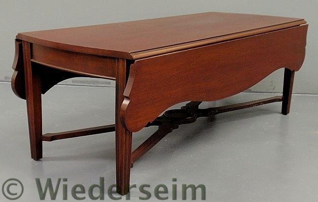 Chippendale style mahogany drop-leaf coffee table: Chippendale style mahogany drop-leaf coffee table by Baker Furniture, with a cross-stretcher base. 17”h.x48”l.x20”w., each leaf 8”