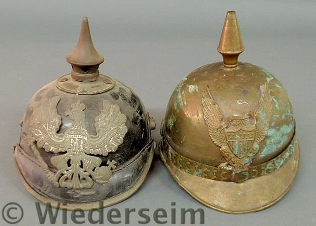 German WWSI leather spike helmet with inscription: German WWSI leather spike helmet with inscription and metal Imperial Eagle 8”h. and a brass American example9”h. . As found.