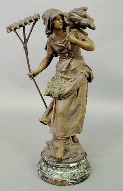 Faux bronze spelter metal figure of a peasant wom: Faux bronze spelter metal figure of a peasant woman holding a hay rake and carrying a bundle of hay on her back mounted on a green granite base with a title plaque “Faneuse” (Haymaker) and signed