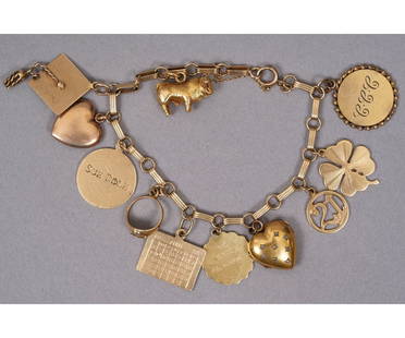 14K GOLD CHARM BRACELET: 14k gold charm bracelet with eleven, mostly 14k, gold charms with safety chain. Bracelet: 7"l / 21 dwt