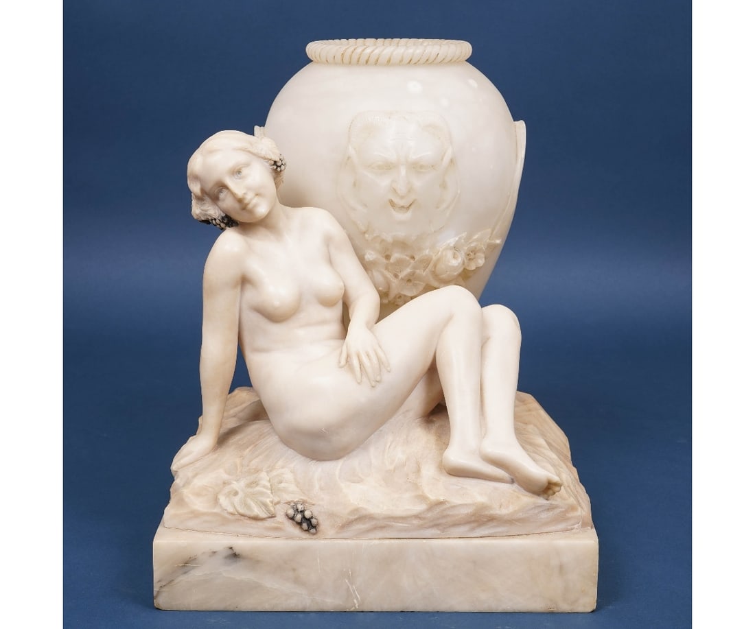 ALABASTER LAMP: Carved alabaster lamp of a nude female maiden with grape leaves in her hair leaning against a wine vessel with carved relief of a devil or Bacchus, early 20th c.. 14"h x 10.5"w x 10"d