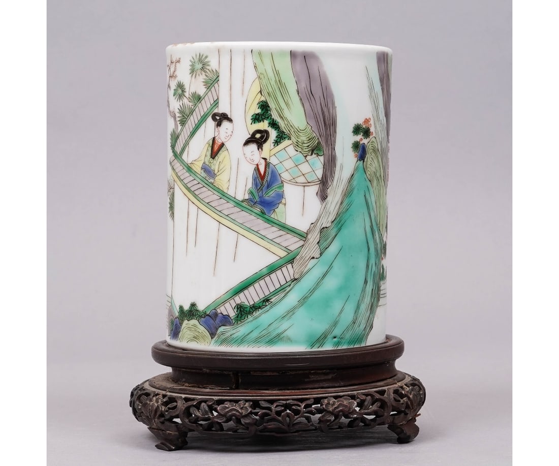 CHINESE PORCELAIN BRUSH POT: Chinese porcelain round brush pot decorated with figures, probably late 19th c., mounted on a wood carved base. 6.25"h x 4.75"dia