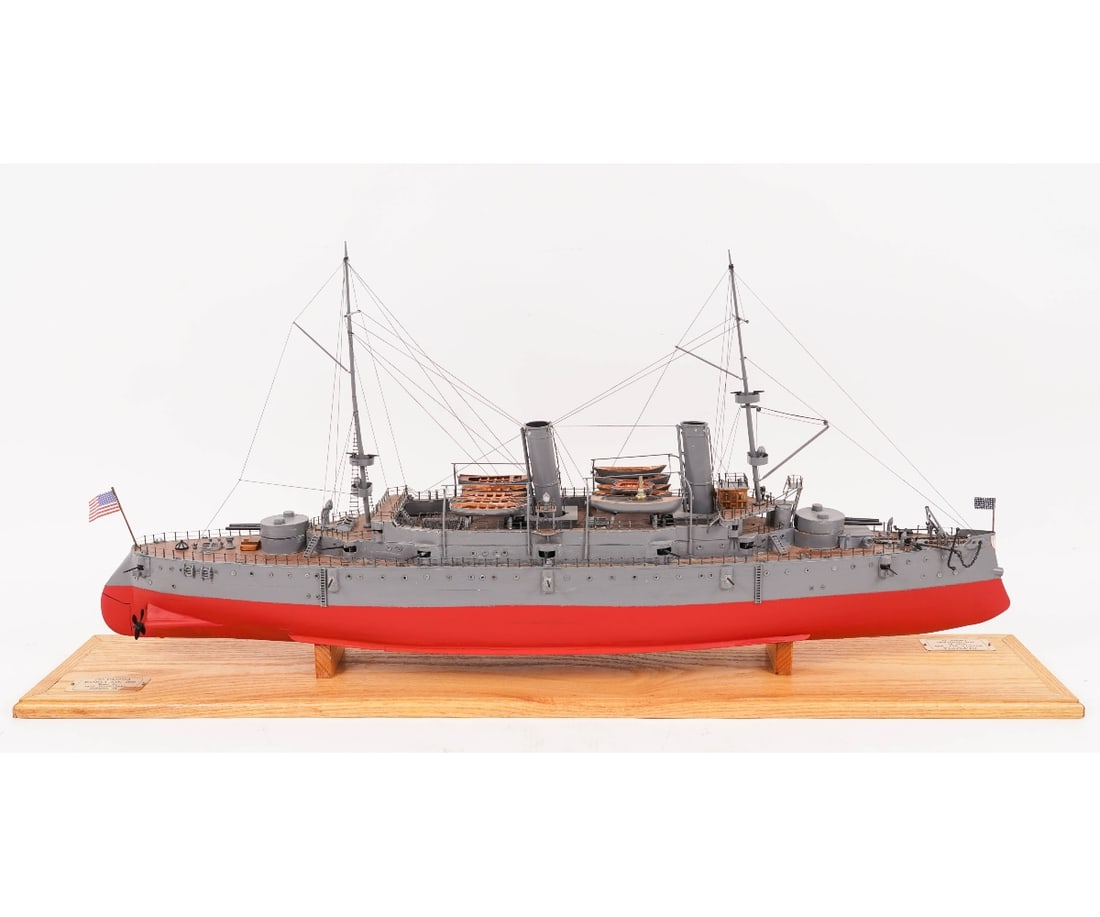 SHIP MODEL USS OLYMPIA: Finely detailed wood ship model of the protected cruiser USS Olympia (C-6), painted grey with red hull, mounted on an oak stand/base with brass plaque inscribed "Olympia, Manila Bay, 1898", made by Pe