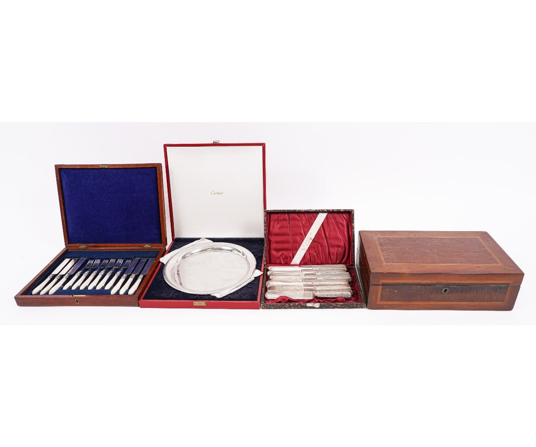 FLATWARE & TABLEWARE: Mahogany cased English dessert set with six forks and six knives, all with carved mother-of-pearl handles; a Cartier pewter spoon dish; 12 cased spoons and knives, and a mahogany inlaid storage box, 5
