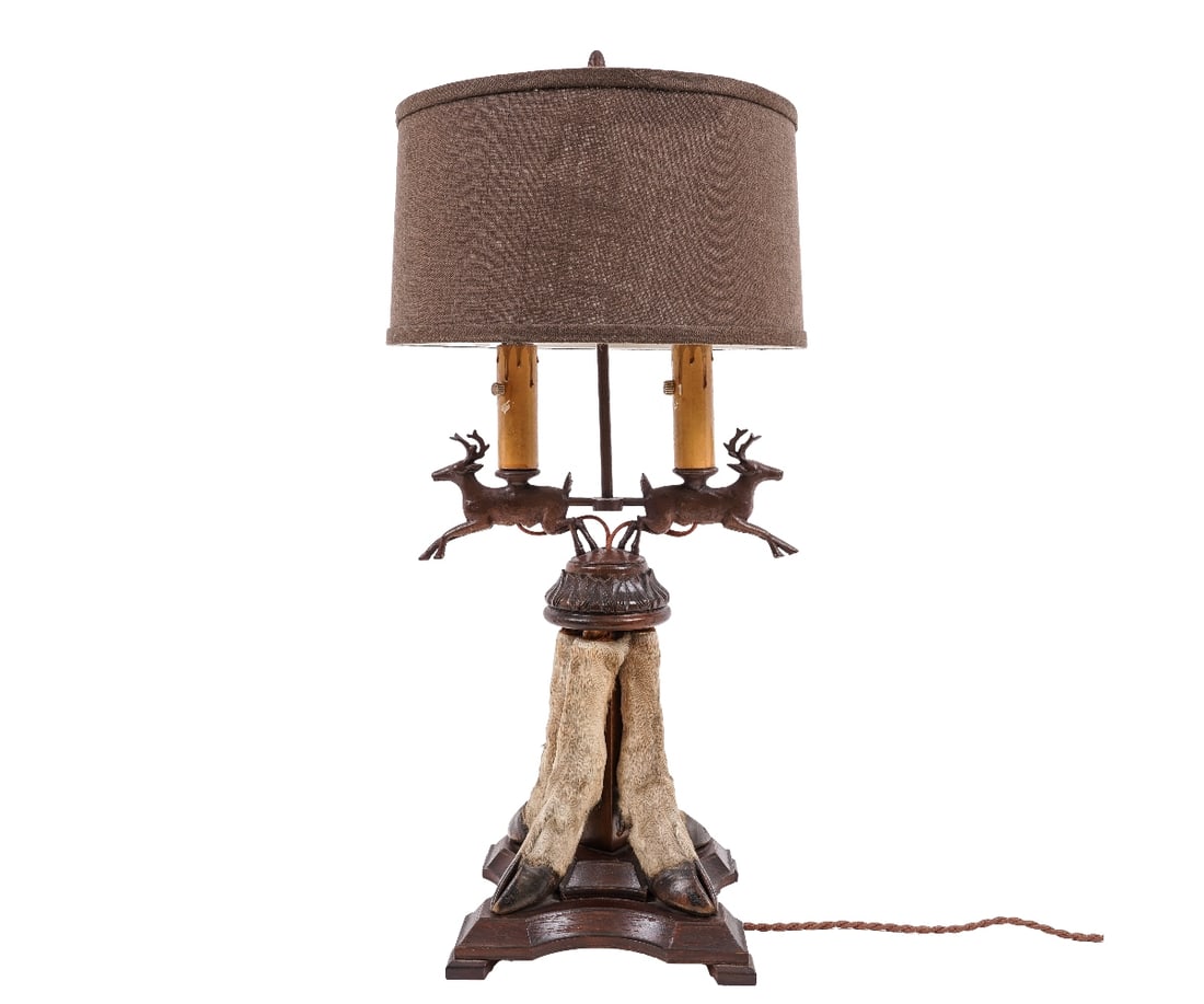 TAXIDERMY HOOF LAMP: Metal running deer and taxidermy hoof lamp mounted on a mahogany stained base with linen shade. 29"h x 12.5"w x 12"dia