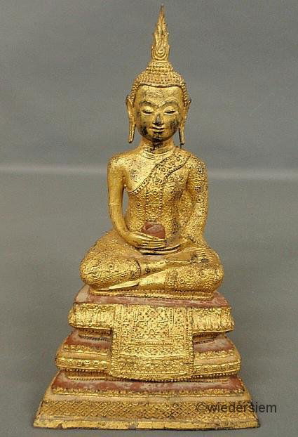 Gilt over metal seated Buddha, 19th c., with an ea: Gilt over metal seated Buddha, 19th c., with an earthenware base. Provenance: Smithsonian Institute. 18.5”h.