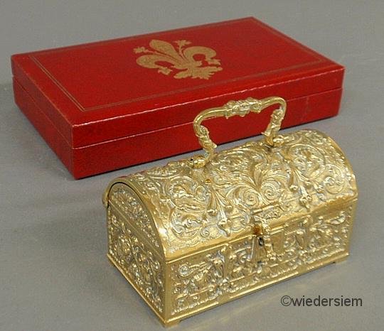 Brass jewelry casket 3”h.x5.125”w.x3”d. and a red : Brass jewelry casket 3”h.x5.125”w.x3”d. and a red leather jewelry box with fleur-de-lis decoration.