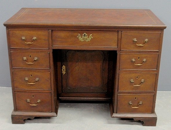 Chippendale style mahogany kneehole desk with a brown l: Chippendale style mahogany kneehole desk with a brown leather top. 30.5”h.x42”w.x22”d.