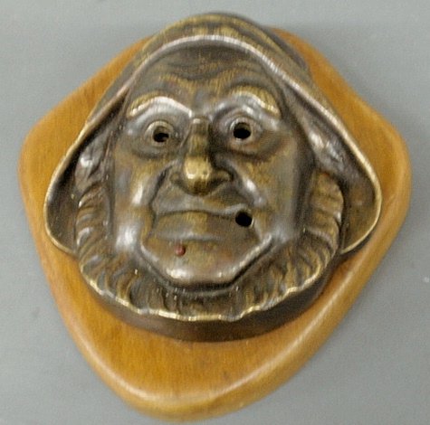 Bronze mask of an â€œOld Saltâ€ fisherman, early 20th: Bronze mask of an “Old Salt” fisherman, early 20th c., mounted on a wood plaque- wiring to back indicates it used to light up the eyes and mouth. 9”x9”