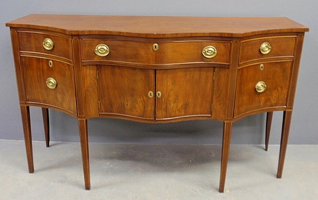 New York Federal inlaid mahogany sideboard, c.1790, wit: New York Federal inlaid mahogany sideboard, c.1790, with a shaped serpentine top and square tapered legs. 40”h.x69.5”l.x25”d.
