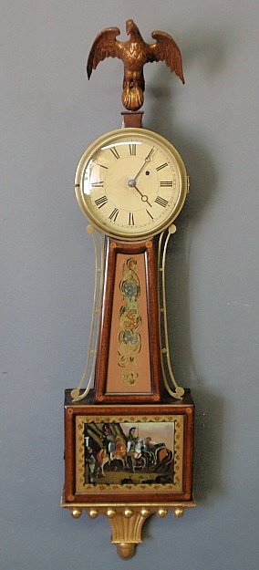 English presentation banjo clock, c.1850, with an eagle: English presentation banjo clock, c.1850, with an eagle finial, dial with Roman numerals, reverse painted glass panels and gilt base. 45"h.