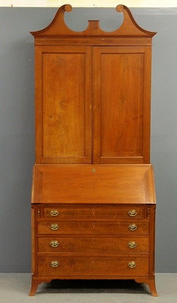 New England Hepplewhite inlaid cherry two-part: New England Hepplewhite inlaid cherry two-part secretary bookcase, circa 1790, the upper section with a broken arch bonnet with pinwheel rosettes above two doors opening to a shelved interior all over