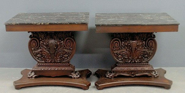 Pair of ornately carved mahogany console tables with: Pair of ornately carved mahogany console tables with marble tops. 33"h., tops 35"w.x22.5"d.