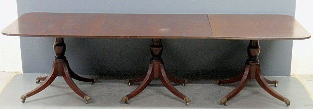 Duncan Phyfe style three-part mahogany banquet table: Duncan Phyfe style three-part mahogany banquet table with brass paw feet. Lacking clips. 29.5"h.x116"l.