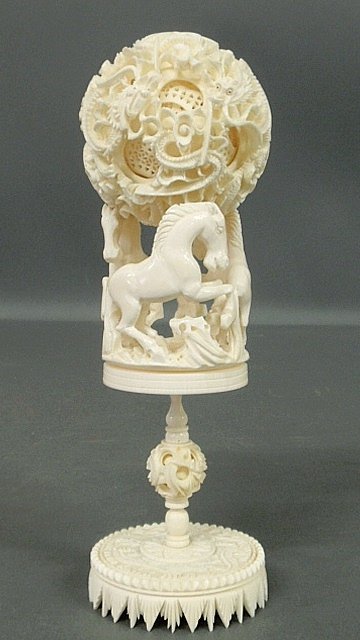 Chinese carved ivory puzzle ball balanced on a: Chinese carved ivory puzzle ball balanced on a galloping horse stand. 9"h., ball 3"dia.