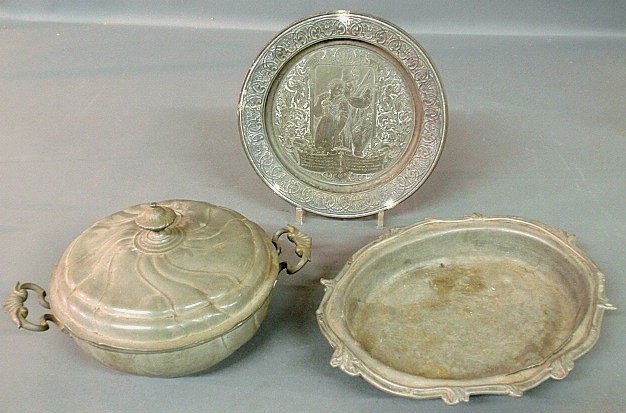 Three pieces of German pewter- plate incised with Black: Three pieces of German pewter- plate incised with Black Forest hunter and wife and verse, probably 19th c., 10"dia., a covered vegetable dish with touchmark, 3"h.x 6"dia., and an oval deep dish 14"w.,
