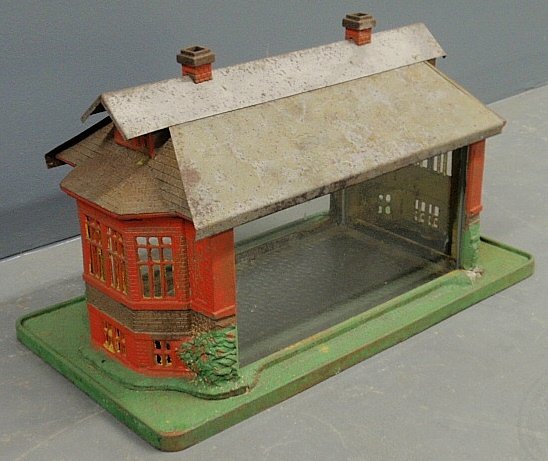 Victorian cast iron and glass terrarium in the form of: Victorian cast iron and glass terrarium in the form of a manor house and with a removable tin roof. 12"h.x20.5"l.x11"w.