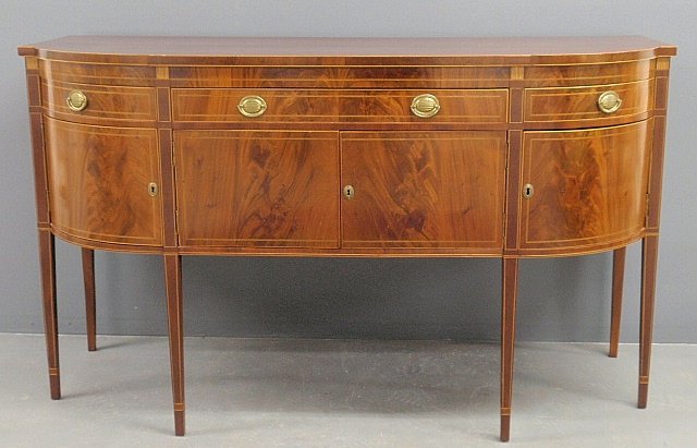 inlaid mahogany sideboard, c.1780, with a D-shaped top: inlaid mahogany sideboard, c.1780, with a D-shaped top above three drawers and four doors, all resting on delicate square tapered legs with banded cuffs. 42h.x72"w.x29"d."