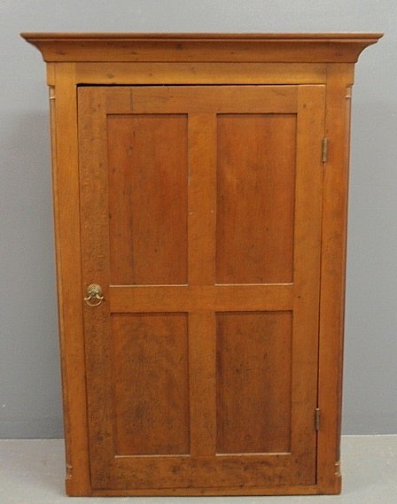 Cherry hanging cupboard, c.1820, with a molded cornice: Cherry hanging cupboard, c.1820, with a molded cornice above a door with four recessed panels flanked by quarter columns. 43.25h.x31"w.x11.75"d."