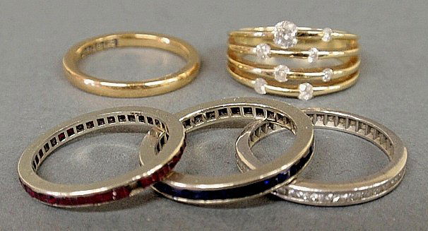 Five ladies rings: 3channel set 14k wg bands-1 diamonds: Five ladies rings: 3channel set 14k wg bands-1 diamonds size 6.25, 1 sapphires size 5.25 and 1 rubies size 4.75- as found, a 10k yg and diamond multi-band ring size 6.75, and an 18k yg wedding band si