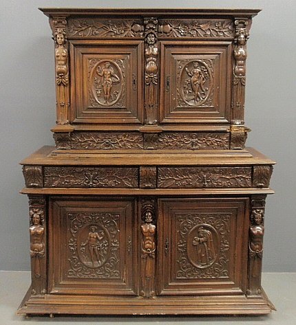 Fine Continental walnut two-part cabinet, 18th c., the: Fine Continental walnut two-part cabinet, 18th c., the upper section with a molded cornice above two figural carved doors and two leaf carved drawers flanked and centered by caryatids above a lower se