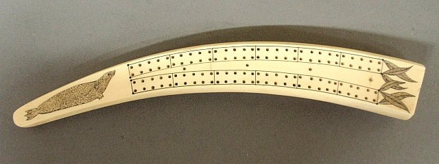 Inuit scrimshaw walrus tusk cribbage board, 19th c.,: Inuit scrimshaw walrus tusk cribbage board, 19th c., with incised seal and walrus decoration. 10.5"x1.5"