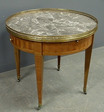 French style round table with a brass galleried marble: French style round table with a brass galleried marble top, two side drawers and two slide-out trays. 22"h.x24.5"dia.