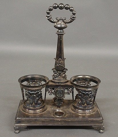 Continental silver bottle stand, probably 19th c.,: Continental silver bottle stand, probably 19th c., hallmarked and decorated with dolphins and with winged paw feet. 13"h.x9.5"w.x5"d.