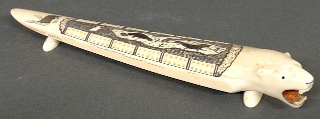 Inuit walrus tusk cribbage board with a polar bear head: Inuit walrus tusk cribbage board with a polar bear head and incised seal and walrus decoration, signed "Charles Mayac". 1.25"h.x11.5"l.