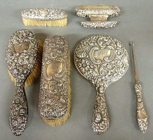 Six-piece sterling silver dresser set- hand mirror: Six-piece sterling silver dresser set- hand mirror 8.5"l.x5"w., nail buff, buttonhook and three brushes.