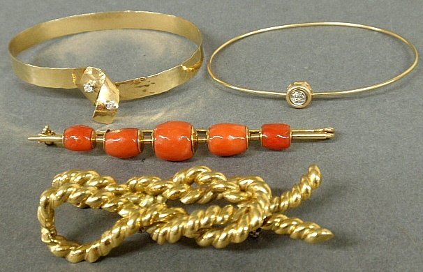 Group of gold jewelry- two bangle bracelets, one with: Group of gold jewelry- two oval bangle bracelets, one with two small diamond accents, 2.375"x2", the other with a bezel set diamond, 2.5"x2", bar pin with barrel form coral beads, and a nautical rope 