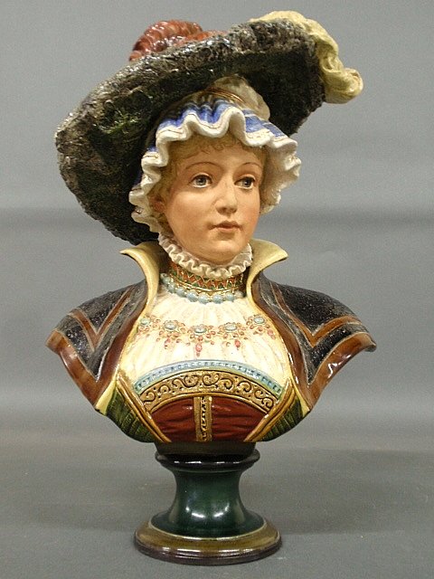 Victorian majolica bust of a woman with a feathered: Victorian majolica bust of a woman with a feathered bonnet, marked with a shield and "908". 18"h.x12"w.x7"d.