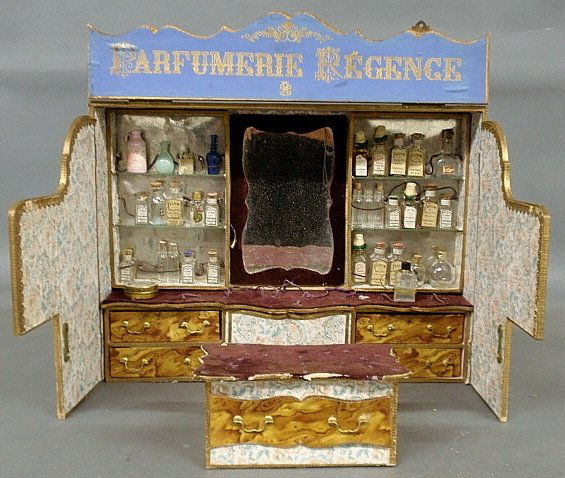 French room-box perfume shop with wallpapered and: French room-box perfume shop with wallpapered and shelved interior, paper labeled bottles and counter. Provenance: Doris Lechler. 13.5"h.x18"w.x4"d.