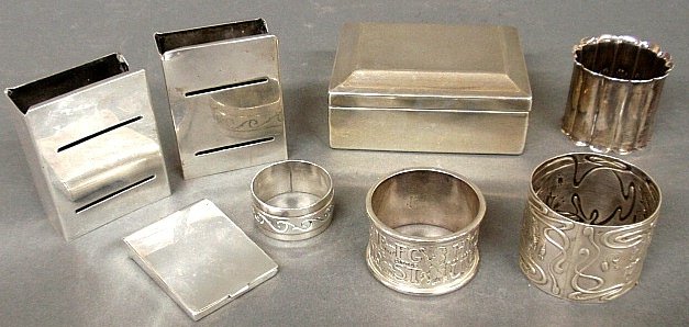 Group of sterling silver to incl. a pair of Allen Adler: Group of sterling silver to incl. a pair of Allen Adler matchbox covers .75"h., cigarette box with wood lining, four napkin rings and a matchbook cover.