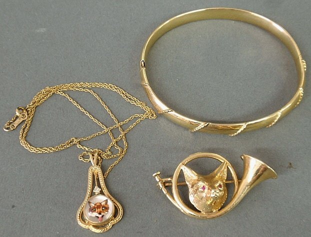 Group of 14k y.g. jewelry to incl. a bangle bracelet,: Group of 14k y.g. jewelry to incl. a bangle bracelet, fox & horn pin, and a reverse crystal intaglio fox lavaliere. 13.5 dwt