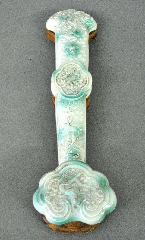 Chinese green glazed porcelain Ruyi scepter, probably: Chinese green glazed porcelain Ruyi scepter, probably 19th c., decorated with dragons, bats and other animals, mounted in a carved wood holder. 4"h.x20"l.x5"w.