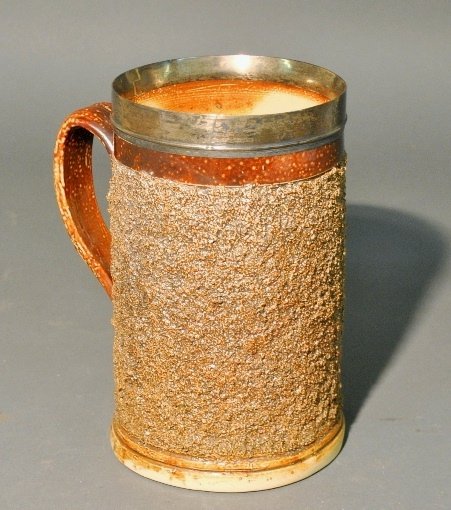 Earthenware tankard with hallmarked silver banded rim: Earthenware tankard with hallmarked silver banded rim monogrammed "N". 8.75"h.x7"w.x5"dia.