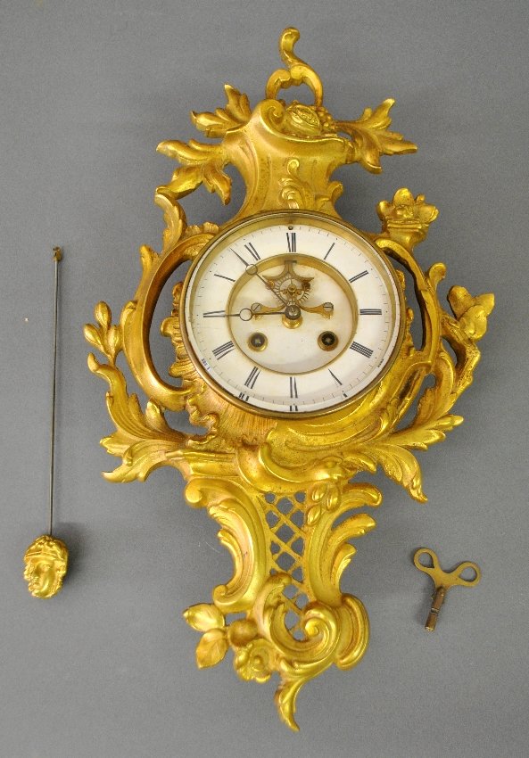 French gilt metal wall clock, late 19th c., with an: French gilt metal wall clock, late 19th c., with an open escapement and beveled glass crystal. 21"h.x12"w.