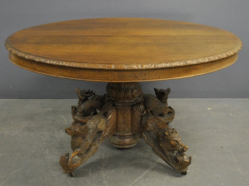 French Black Forest center table, late 19th c., with: French Black Forest center table, late 19th c., with carved animal base. 29"h.x50"l.x44"w.
