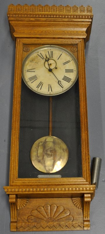 Wm. Gilbert oak cased wall clock with a carved cornice, (1 of 2)