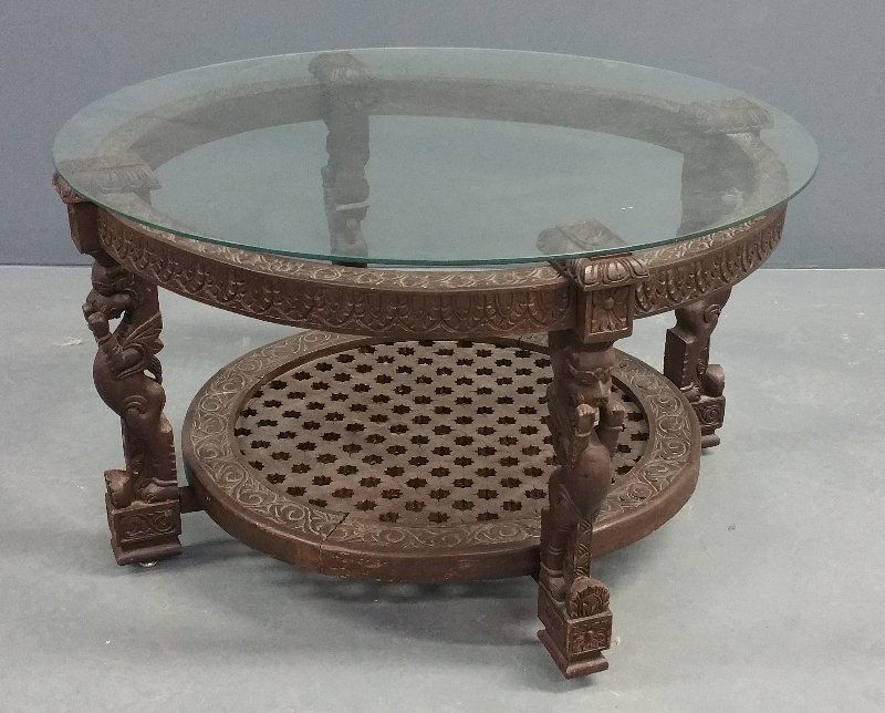 A fine carved circular African table with a glass top (1 of 2)