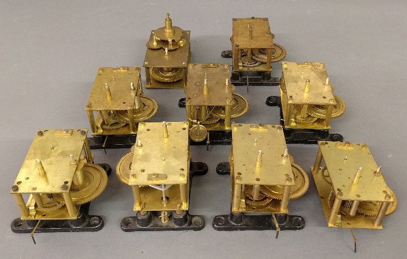 Grouping of nine brass wall clock works. As found. (1 of 1)