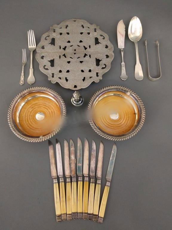 Bone handled knives: Nine bone handle knives, Christofle tablespoon, George III sugar tongs, silver bullion knife, pickle fork, Sheffield wine coasters, candlestick finial, trivet, etc.