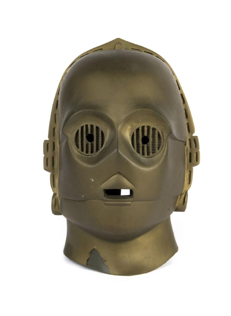 Don Post "Star Wars" C3PO Mask.: (Don Post, c.1977) An original C3PO mask created by Don Post Studios. The mask was created in gold painted thick rubber and has the markings "C-3PO" and "20th Century Fox - 1977" on the back of the ne