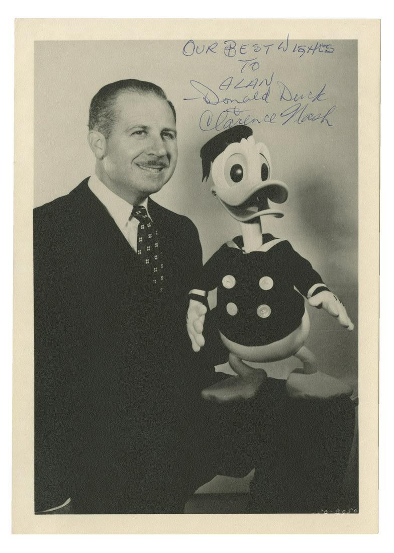 Clarence Nash & Donald Duck Signed Photo.: (Walt Disney Studios, c.1979) A black and white publicity photo of Disney Legend Clarence Nash, who voiced Donald Duck for over 50 years. Nash is seen in this photo with a large Donald Duck doll on hi
