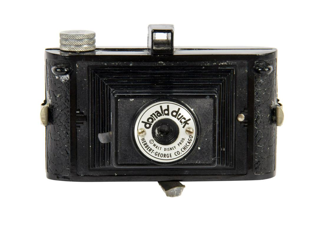 Donald Duck Camera.: (Herbert George Co, 1940s) A vintage Donald Duck camera created by Herbert George Company. The hard bakelite camera body features molded imagery of Donald and his nephews on the back side below the vi