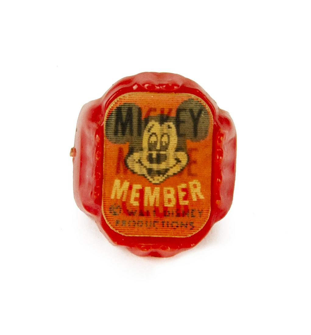 Mickey Mouse Club Red Plastic Lenticular Ring.: (Disneyland, 1950s) A red plastic membership ring for the Mickey Mouse Club. The lenticular imagery changes between the text "Mickey Mouse Club" and an image of Mickey with the word "member" written b
