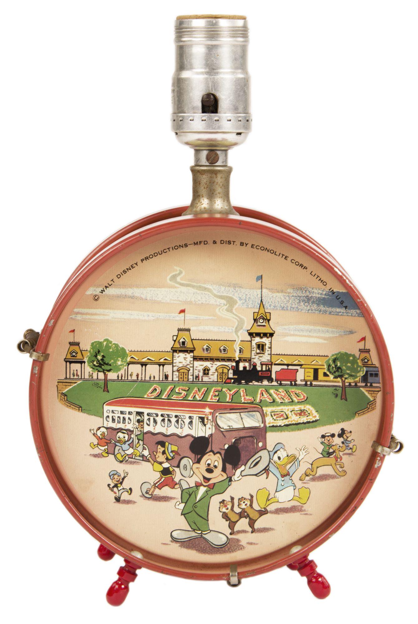 Disneyland Tin Litho Drum Lamp.: (Disneyland, c.1955) A colorful tin drum lamp featuring iconic Disney characters in front of Disneyland. The lamp measures 6.25"x3.75" and 10" tall. The condition is good with minor wear throughout, i