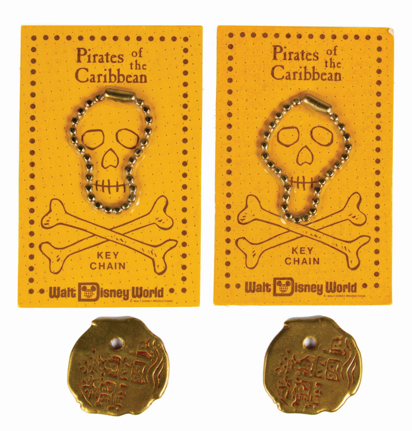 Pair of Pirates of the Caribbean Doubloon Keychains.: (Walt Disney World, c.1970s) A pair of Pirates of the Caribbean souvenir doubloons with corresponding skull keychains. These doubloons were designed to be purchased separately and could be custom engr