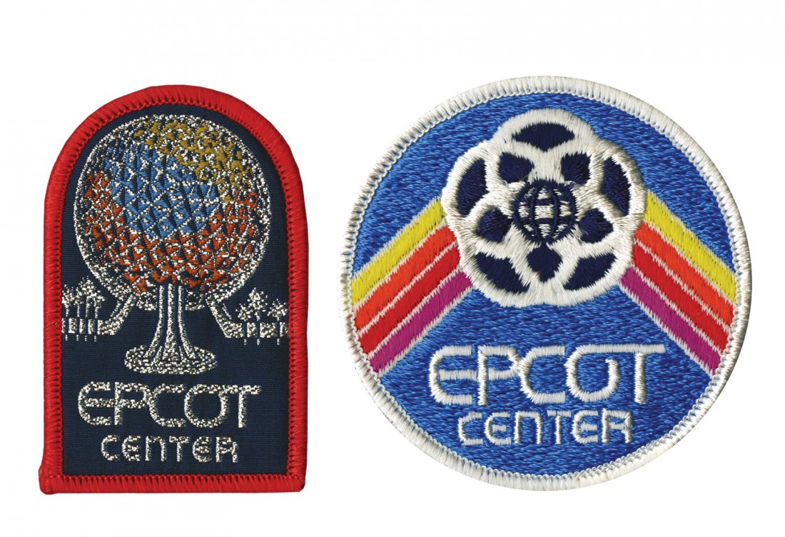 Pair of Epcot Center Patches.: (Epcot, c.1970s-80s) A pair of embroidered Epcot Center patches. One patch is accentuated with silver-lettering and a glittering image of Spaceship Earth, and the other patch features the Epcot emblem